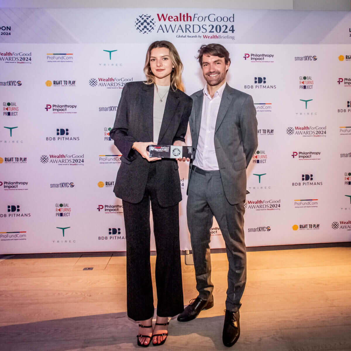 Chris Curtis and Iona Reininger holding ARC's WealthBriefing Wealth For Good Award